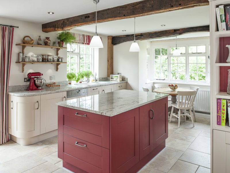 country cottage kitchen with red island and tiled floors