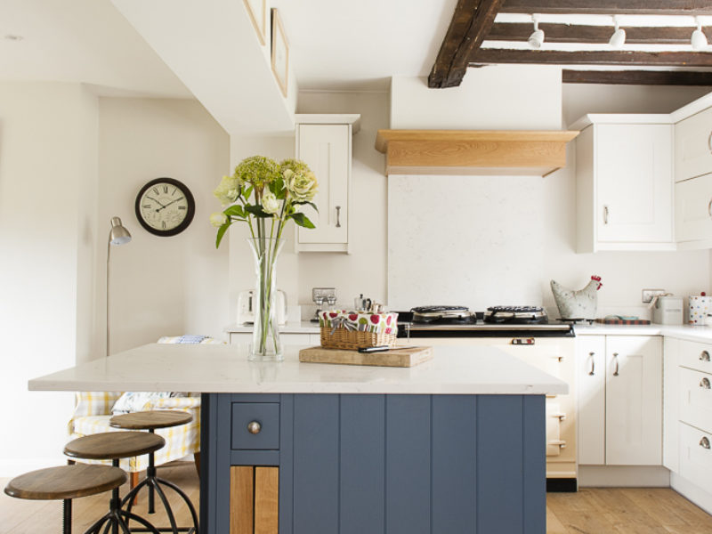 cottage kitchen with blue island and barstools