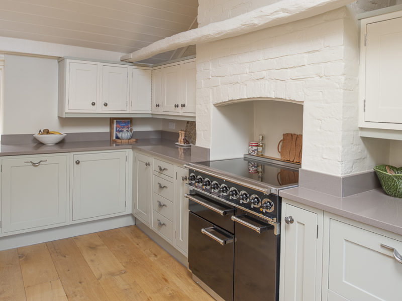 green kitchen with brick chimney and range cooker