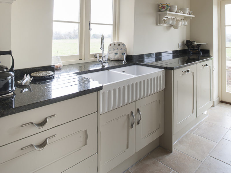 galley kitchen with black worktops and tiled floor