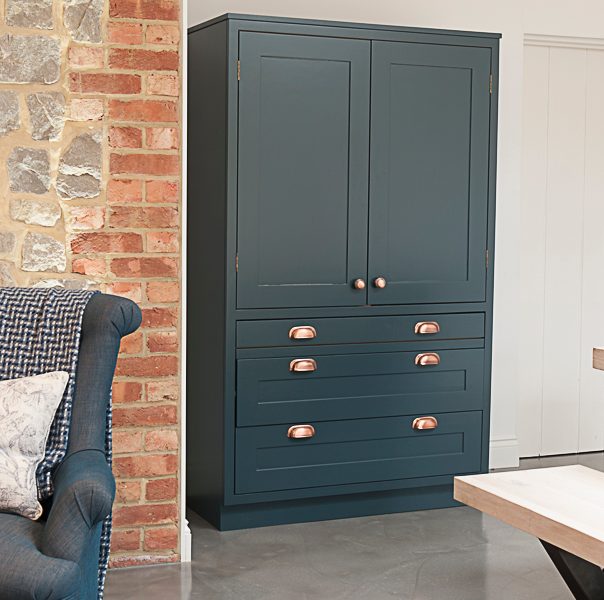 blue kitchen with freestanding storage and copper details