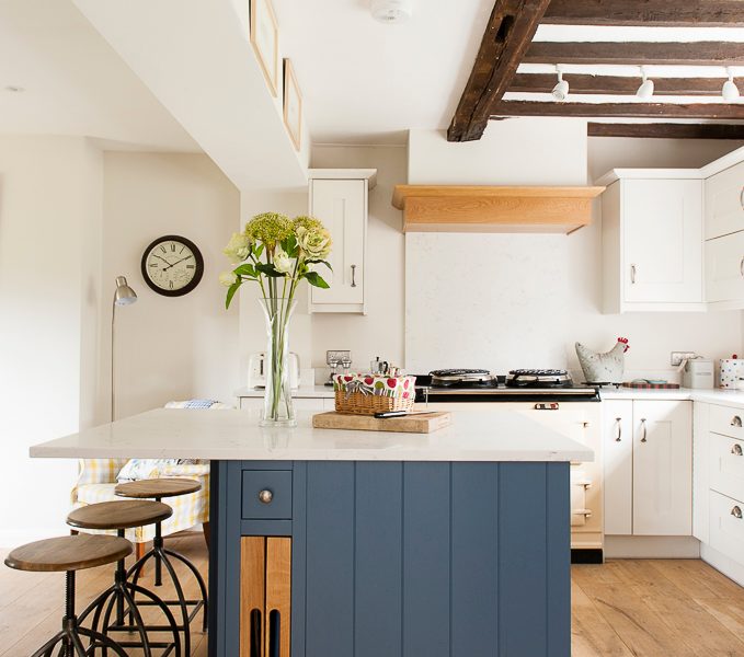cottage kitchen with blue island and barstools