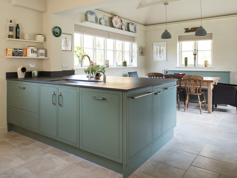 trendy green kitchen with island and pendant lamps