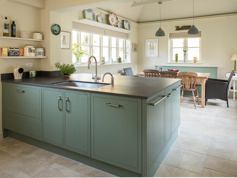 green kitchen island with tiled floor and pendant lights