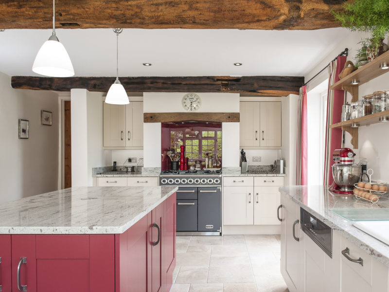 country cottage kitchen with red island and pendant lamps