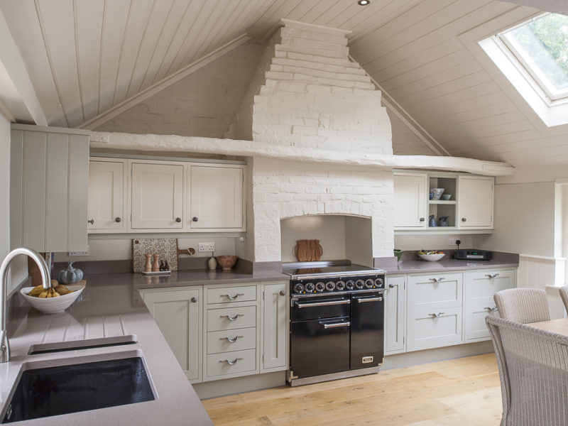 green kitchen with grey worktops and wood floor